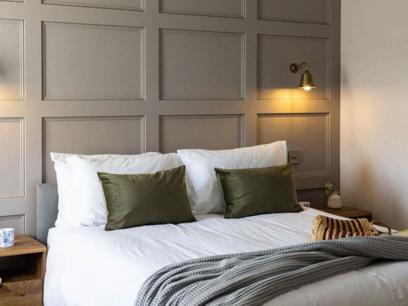 Comfortable bedroom at Castle View Cottage with stylish panelling and soft grey throw.