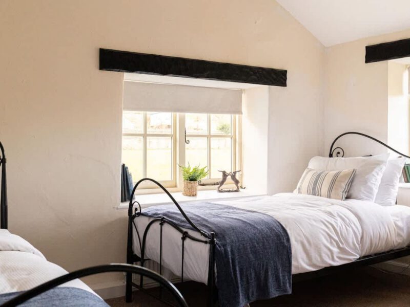 Twin beds with countryside views at Yew Tree Cottage farm stay.