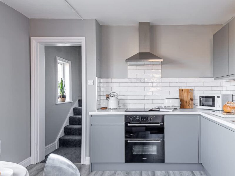 Modern grey kitchen with oven and microwave at Crescent View holiday let.