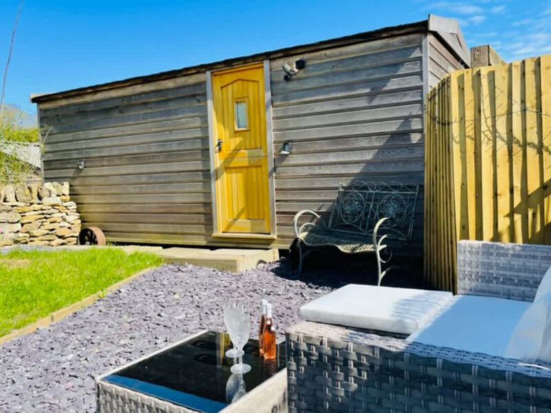 Shepherd's Hut cosy farm stay with outdoor seating area.