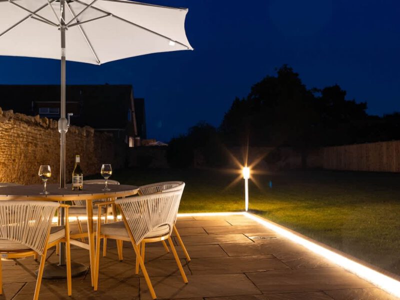 Patio dining area at Castle View Cottage with ambient lighting at night.