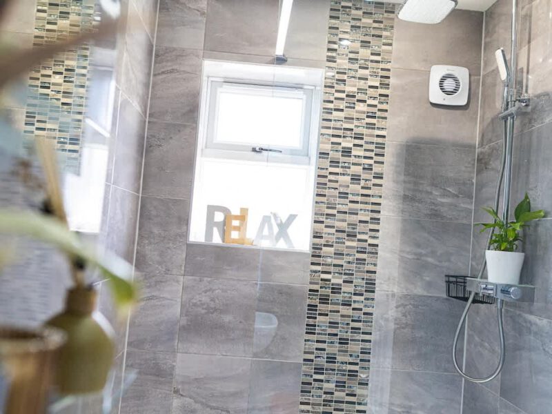 Modern shower with "RELAX" decor at Townhouse Harbour Retreat.