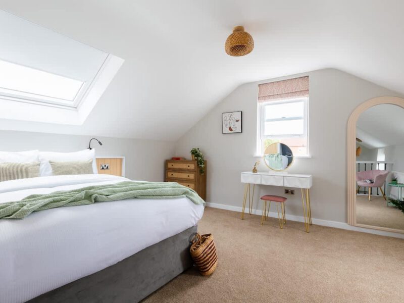 Cozy bedroom with skylight and vanity at Ivy Mews barn stay.
