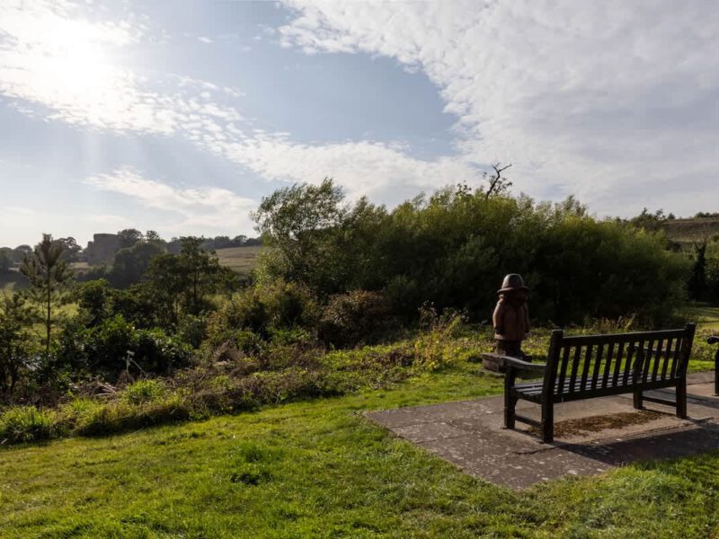 Castle View Cottage: scenic grounds with a statue and benches, overlooking countryside.