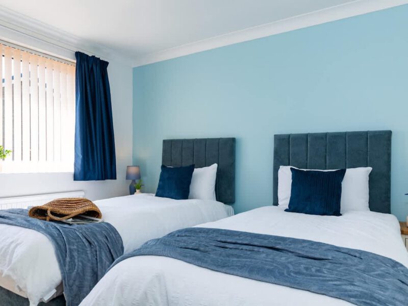 Twin bedroom with blue accents at Coastal Village Hideaway.