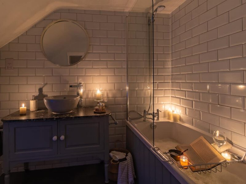 Relaxing bathroom with candles and book at dog-friendly Garth Cottage.