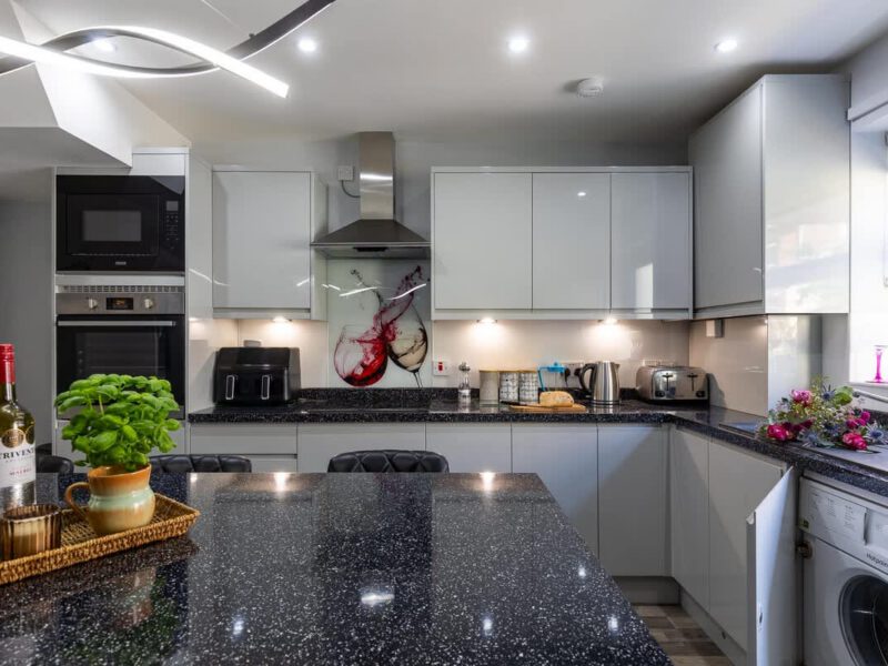 Modern kitchen with wine splash splashback at Townhouse Harbour Retreat.