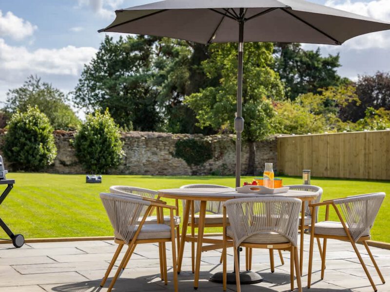 Outdoor dining area with BBQ and garden at Castle View Cottage.