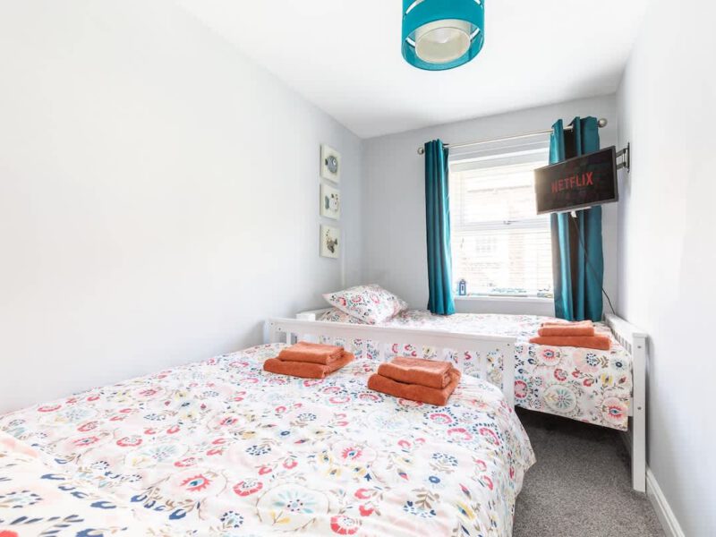 Twin beds with colourful bedding in Townhouse Harbour Retreat holiday let.