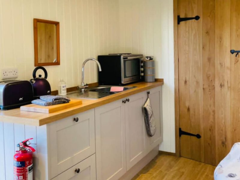 Compact kitchen in Shepherd's Hut cosy farm stay, sleeps 2.