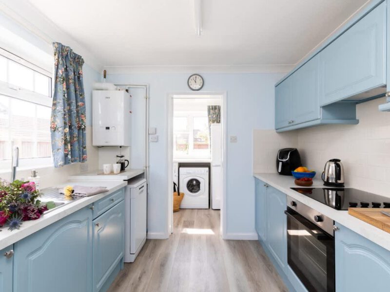 Coastal Village Hideaway kitchen with blue cabinets and modern appliances.