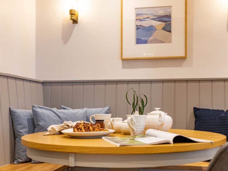 Breakfast nook with tea set and pastry at Castle View Cottage.