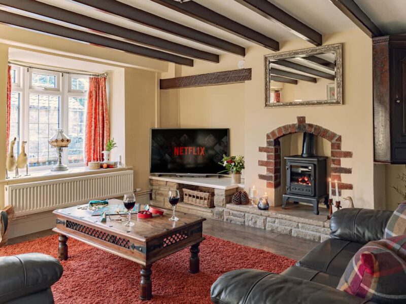 Cozy living room with wood burner at dog-friendly Garth Cottage.