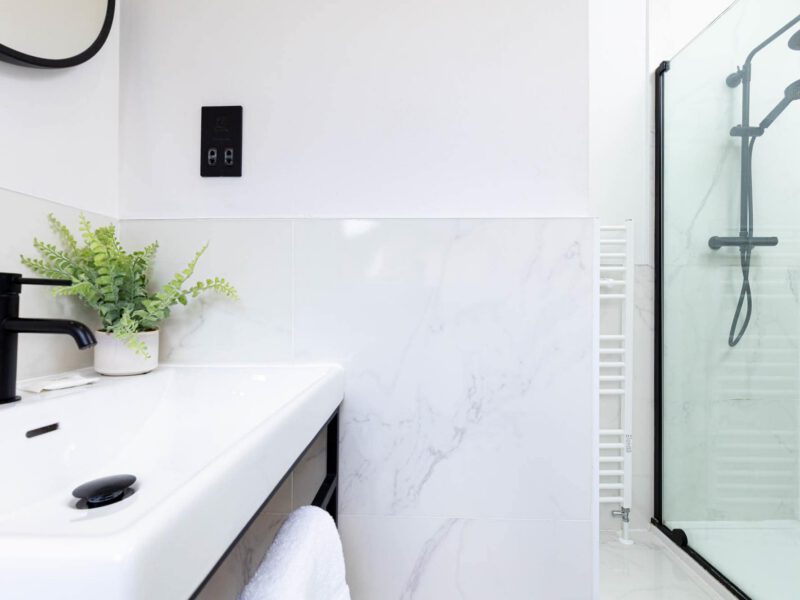 Modern bathroom with sink and walk-in shower at Ocean Pearl holiday let.