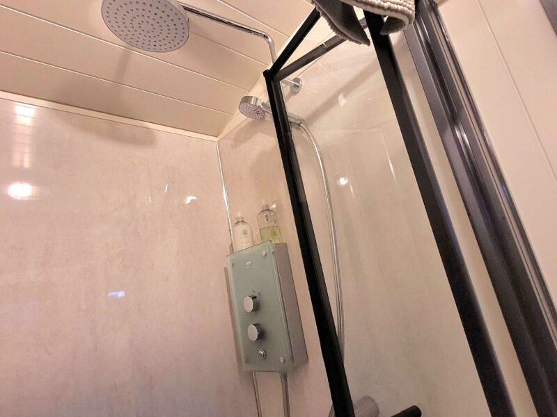 Modern shower enclosure with dual shower heads at Plank Bridge shepherds hut.