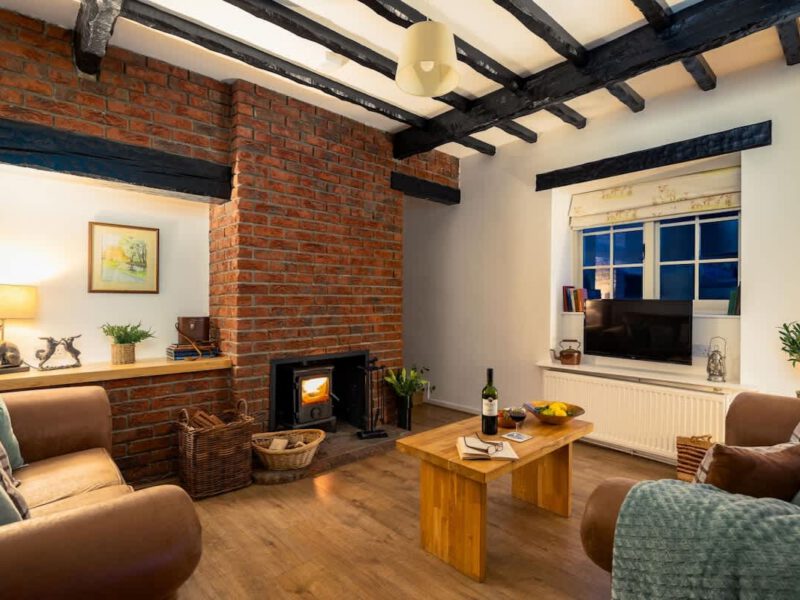 Cozy living room with fireplace at Yew Tree Cottage farm stay.