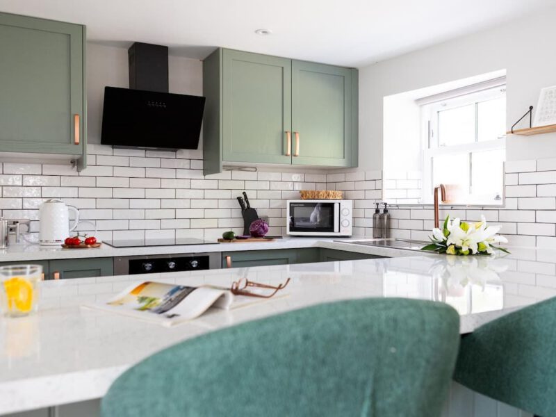 Modern kitchen with sage green cabinets at Ivy Mews village barn.
