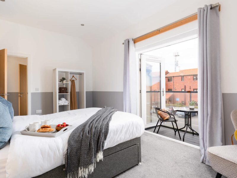 Welton View Escape bedroom with breakfast tray and balcony access.