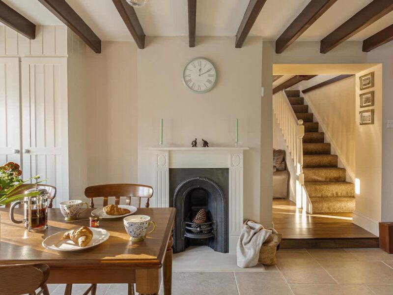 Dining area with fireplace and stairs at dog-friendly Garth Cottage.