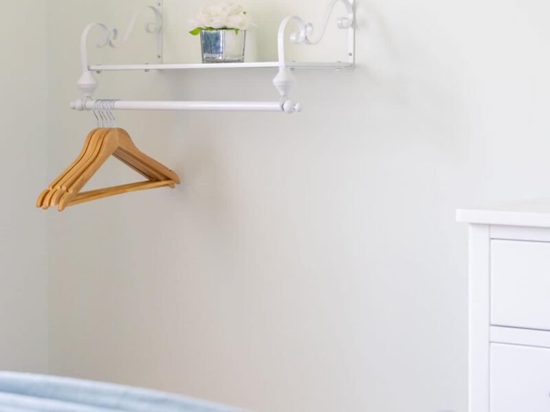 Coastal Village Hideaway: empty hangers and a book on a bed.