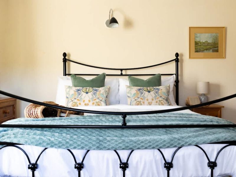 Comfortable double bed with decorative pillows at Yew Tree Cottage farm stay.