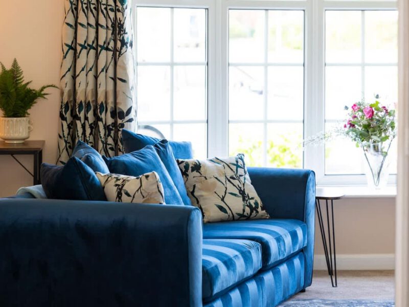 Comfortable blue sofa with floral cushions at Coastal Village Hideaway.