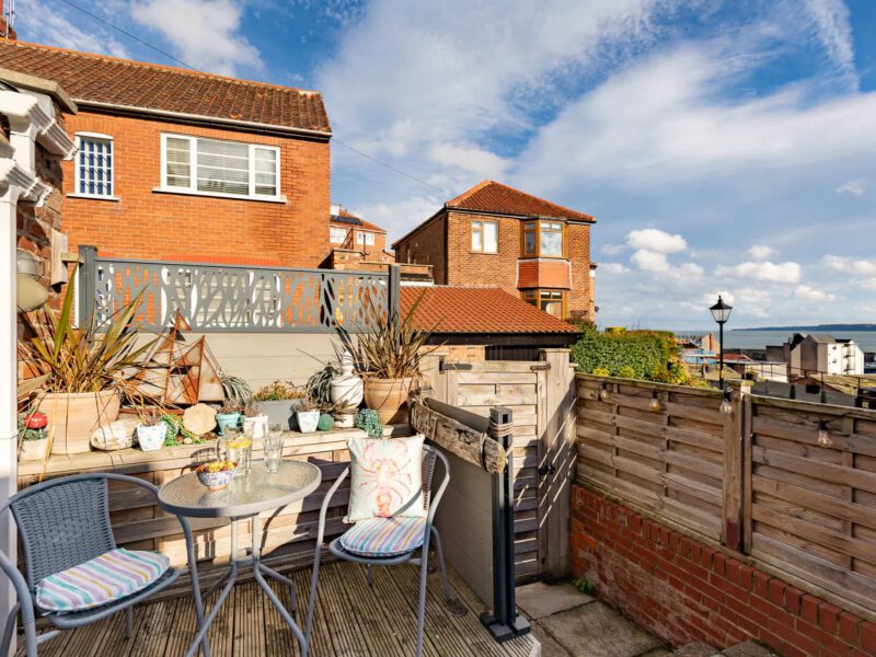 Harbour View House balcony with sea views and seating for guests.