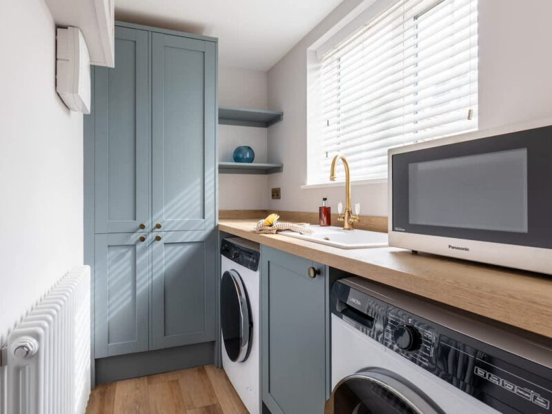 Laundry room with washer, dryer, and sink at Castle View Cottage.