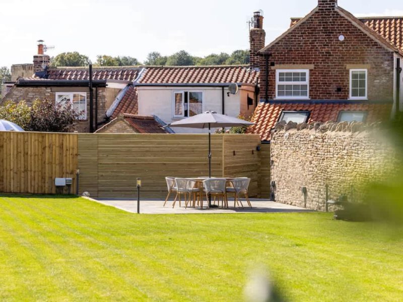 Patio dining area with umbrella at Castle View Cottage, a holiday let.