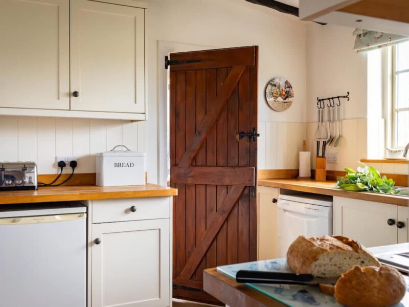 Yew Tree Cottage kitchen with rustic wooden door and fresh bread.