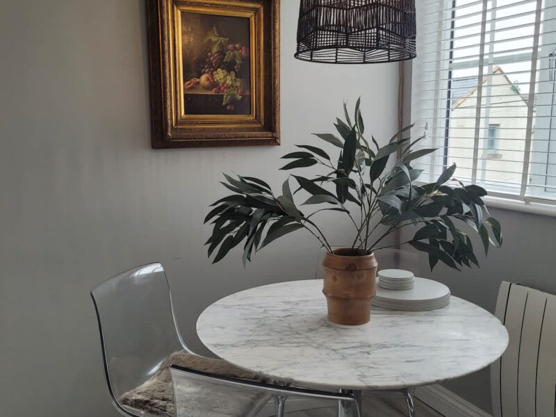 Dining area at Crescent View holiday let with marble table and modern chairs.