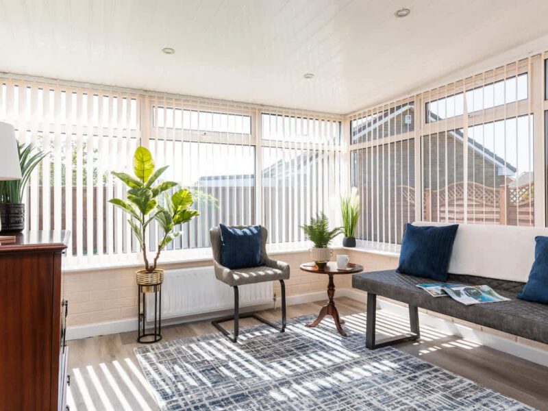 Sunlit conservatory seating area at Coastal Village Hideaway holiday let.