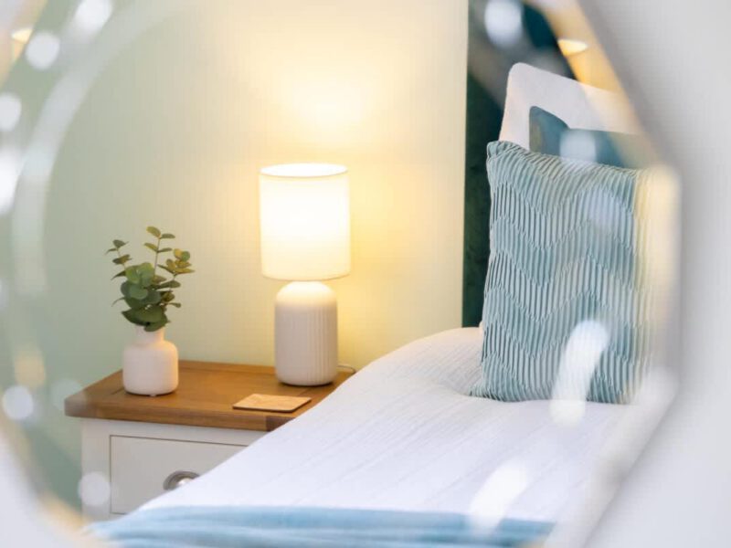 Coastal Village Hideaway: bedside lamp and plant on nightstand.