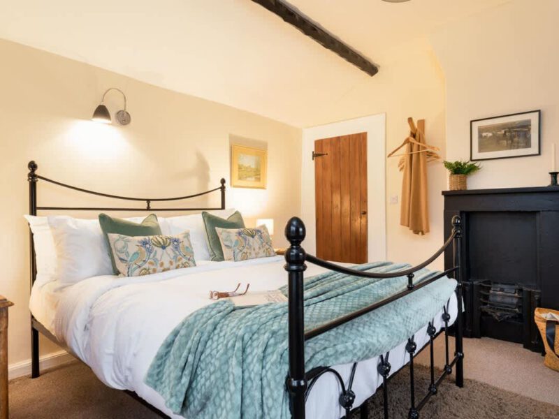 Cozy bedroom with fireplace at Yew Tree Cottage farm stay.