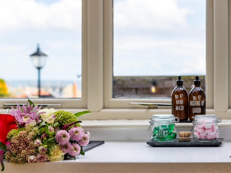 Floral arrangement and toiletries with sea view from Harbour View House.