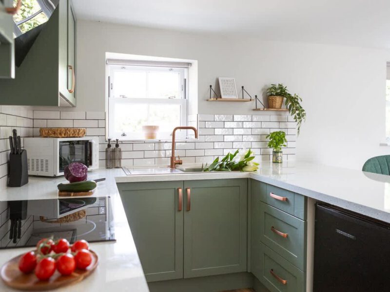 Modern kitchen with sage green cabinets and copper accents at Ivy Mews barn.