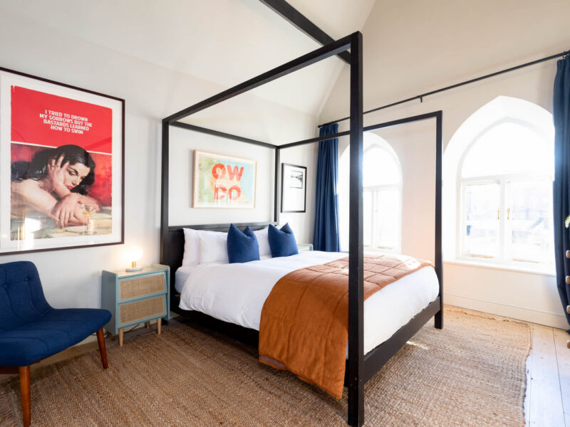 Four-poster bed in a stylish bedroom at Old Town House converted church holiday let.