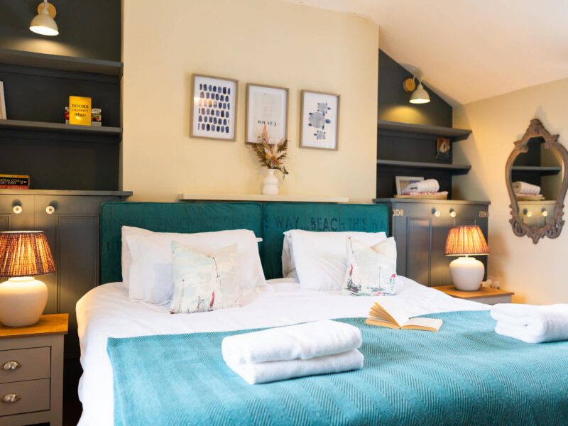 Comfortable bedroom at Harbour View House with sea-themed decor and sea views.