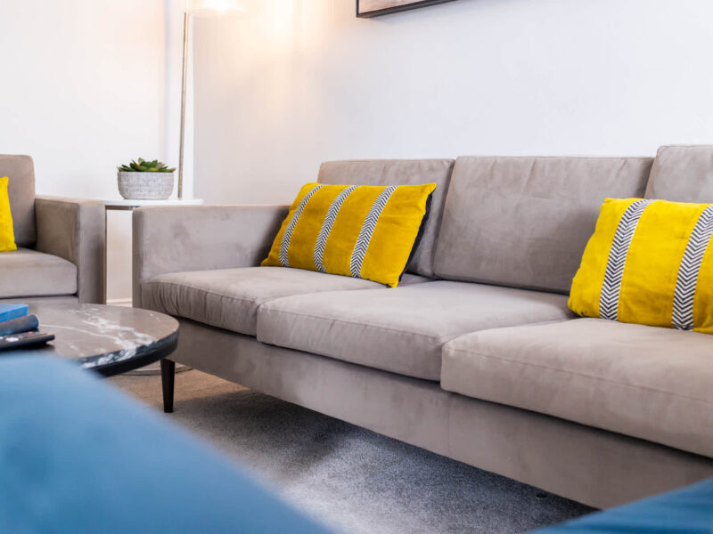 Comfortable lounge seating with yellow accent pillows at Ocean Pearl holiday let.