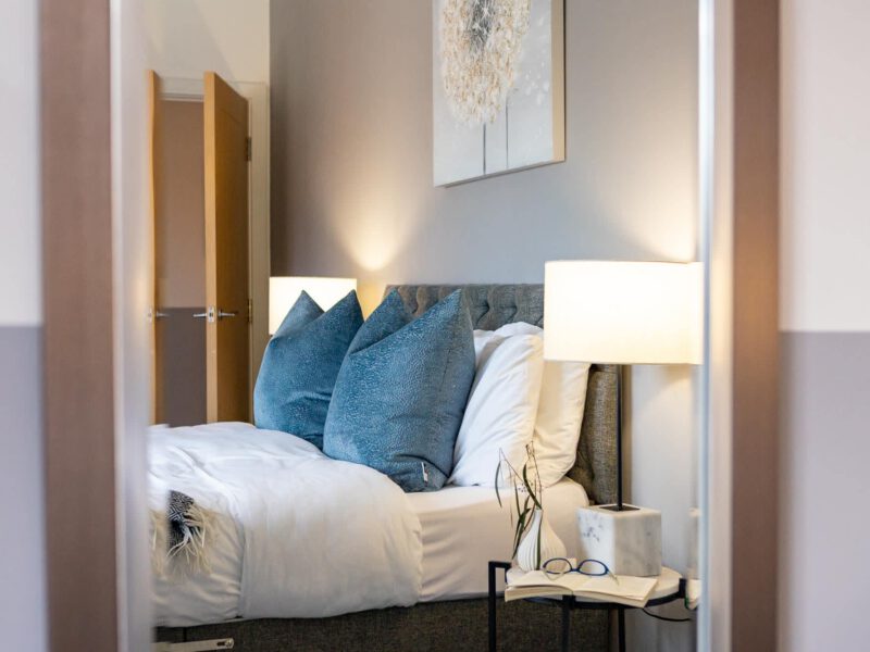 Comfortable bedroom with blue accent pillows at Welton View Escape holiday let.