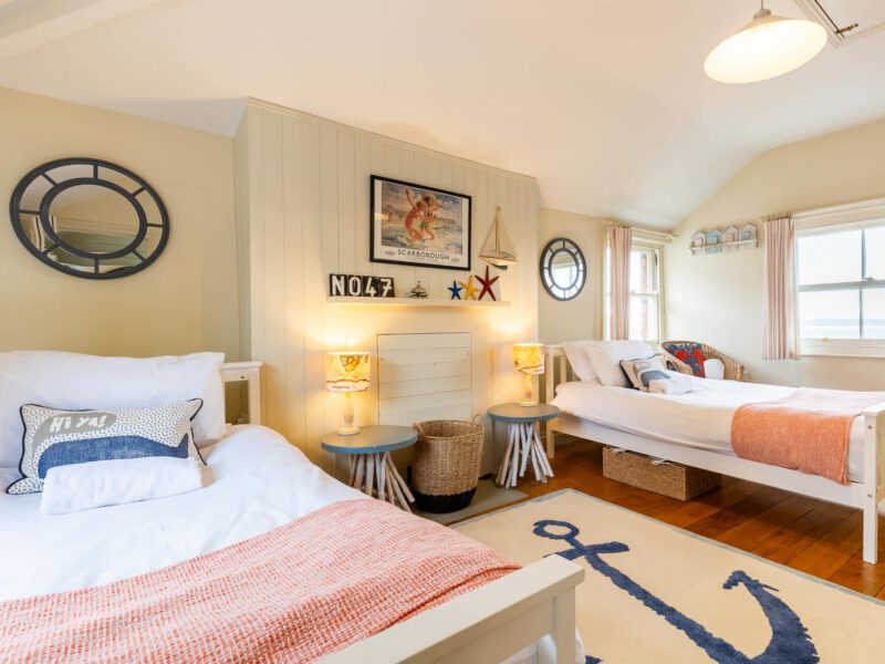 Nautical-themed twin bedroom at Harbour View House with sea views.