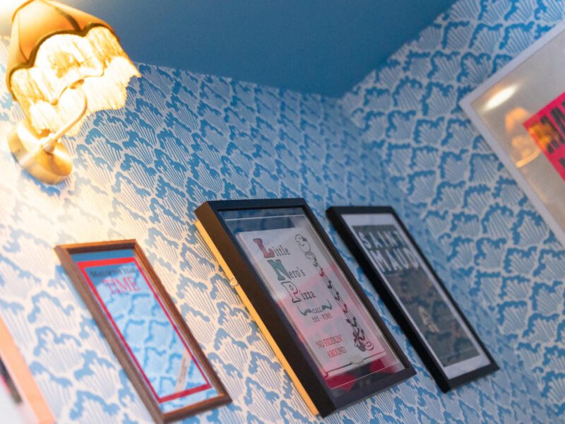 The Loft by the Bay: quirky decor with framed pizza menu and vintage lamp.