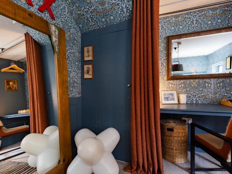 Stylish dressing area with patterned wallpaper at The Loft by the Bay.
