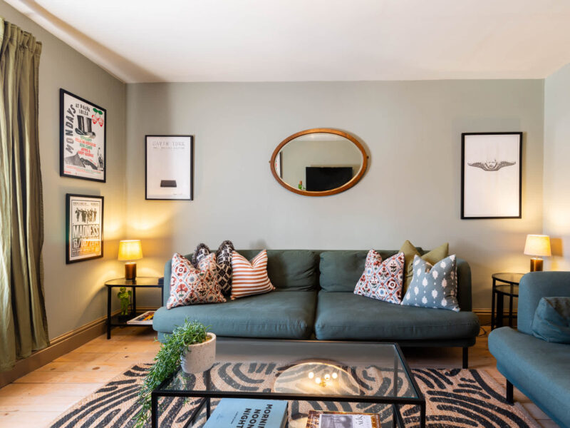 Stylish living room with green sofas and patterned cushions at Old Town House.