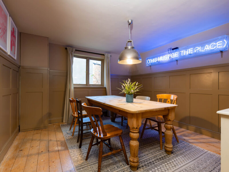 Dining area with neon sign at Old Town House, a dog-friendly converted church.