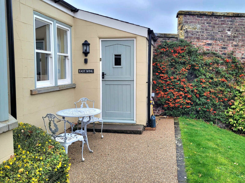 East Wing holiday let entrance with seating and garden access.