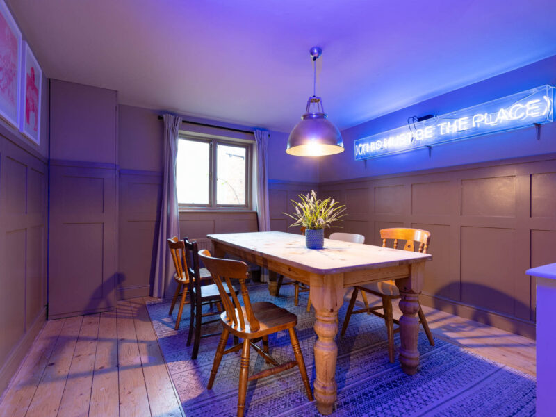 Dining area with neon sign at Old Town House converted church rental.