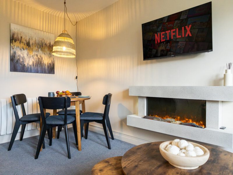 Dining area with fireplace and Netflix TV in Penthouse Suite.