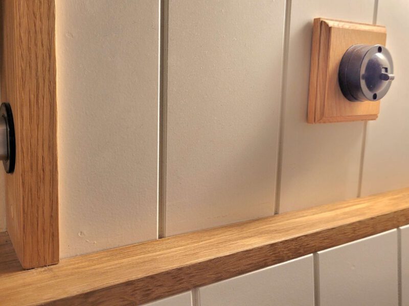Wooden shelf and vintage light switch in Plank Bridge shepherds hut.