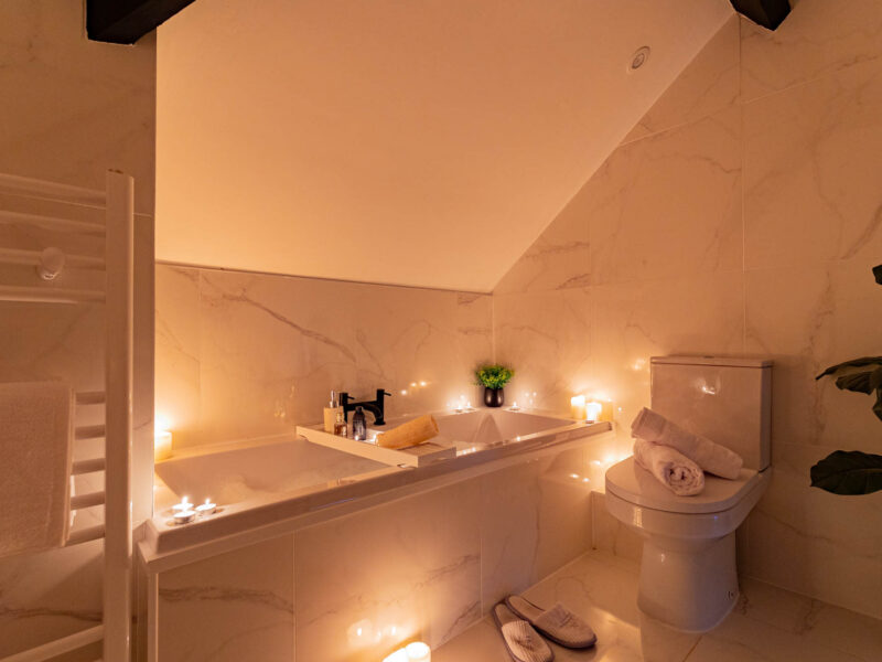 Luxurious bathroom with candles and bathtub at Ocean Pearl holiday let.